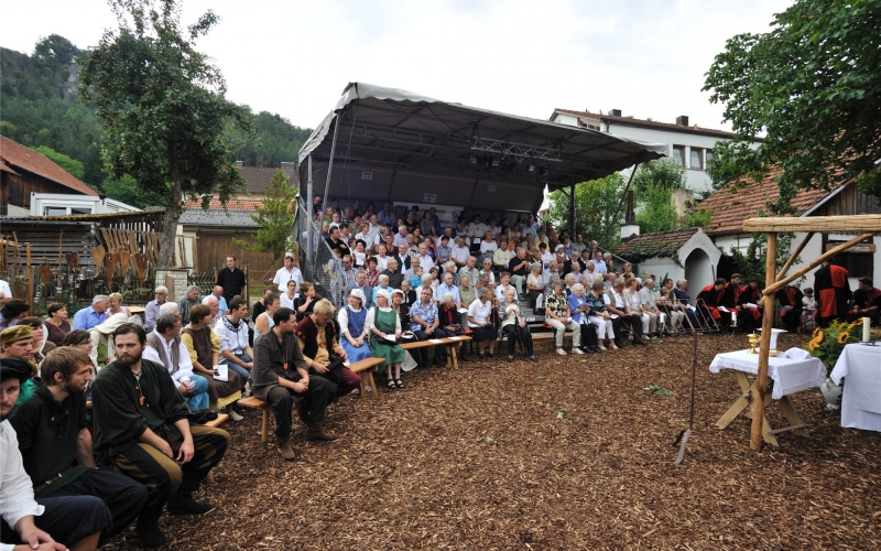 Festgottesdienst auf dem Gelände der Aufführung zum Meier Helmbrecht. Zuschauer unter der Tribüne und seitlich auf Bänken.